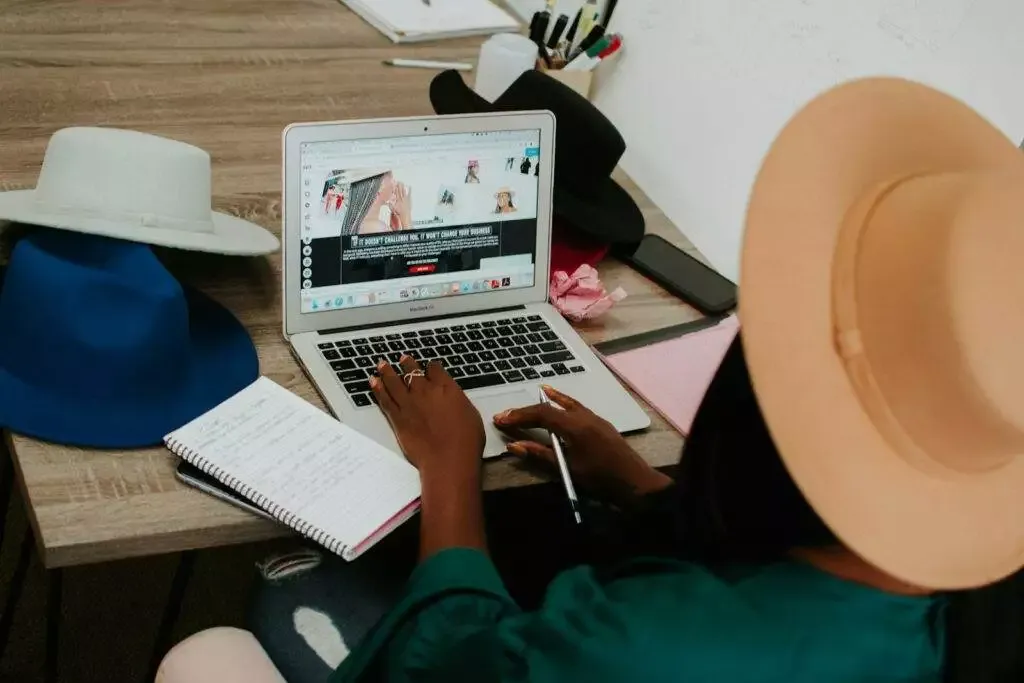 Freelancer Person Using Macbook Air On Brown Wooden Table